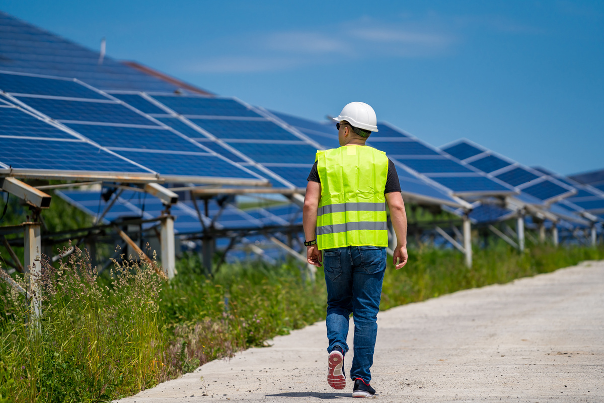 Engeneer in worker helmet on solar panels background. Solar power panel. Green energy. Electricity. Power energy pannels.